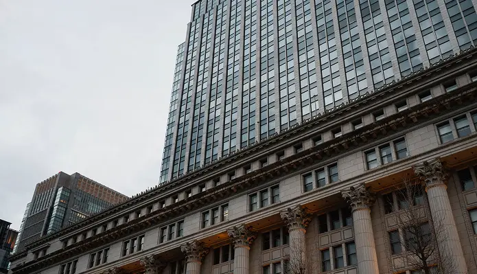 Modern skyscraper with classic stone facade and pillars